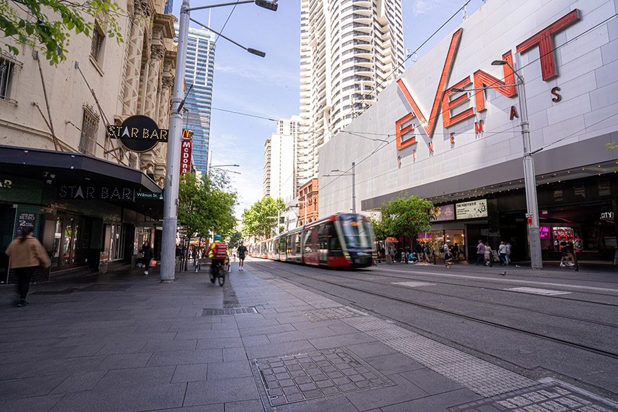 A tram passes Event Cinemas and Star Bar in George Street, Sydney CBD.