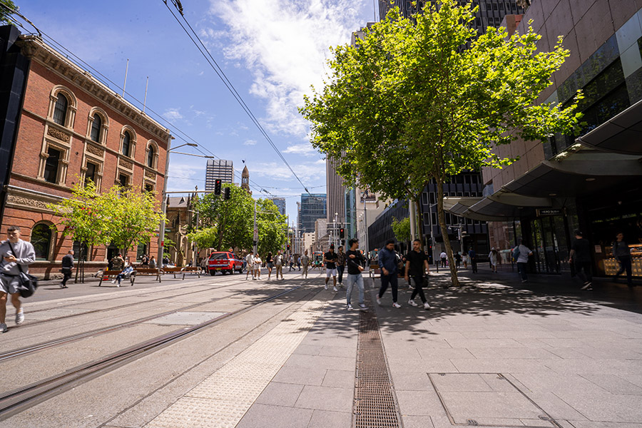 Pedestrians cross the tram tracks in the new streetscape on George Street, Sydney CBD.