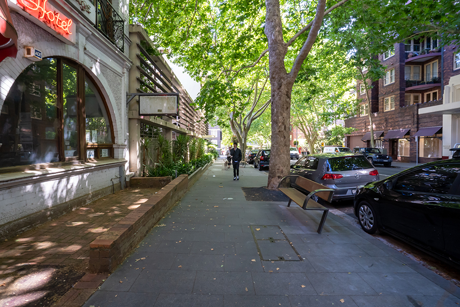 Pedestrians walk down Macleay Street in Potts Point with new landscaping and seating.