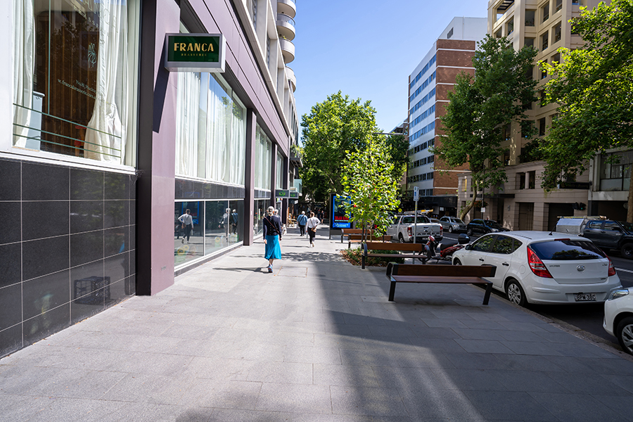 Pedestrians walking down the new Macleay Street streetscape in Potts Point with new seating areas.