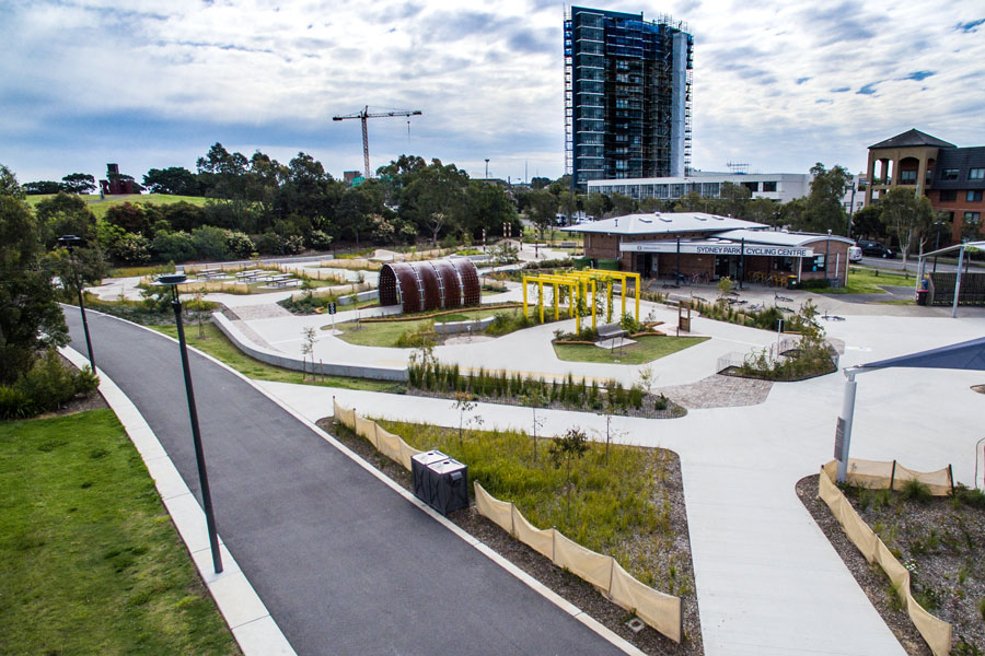 The front of the cycle path, a tunnel and yellow arbour and the Sydney Cycling Centre building visible.